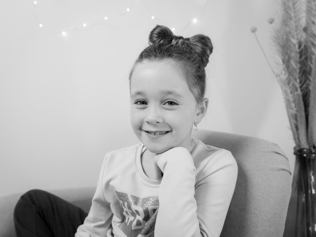 Portrait enfant petite fille souriante en noir et blanc, séance photo enfant Suisse romande