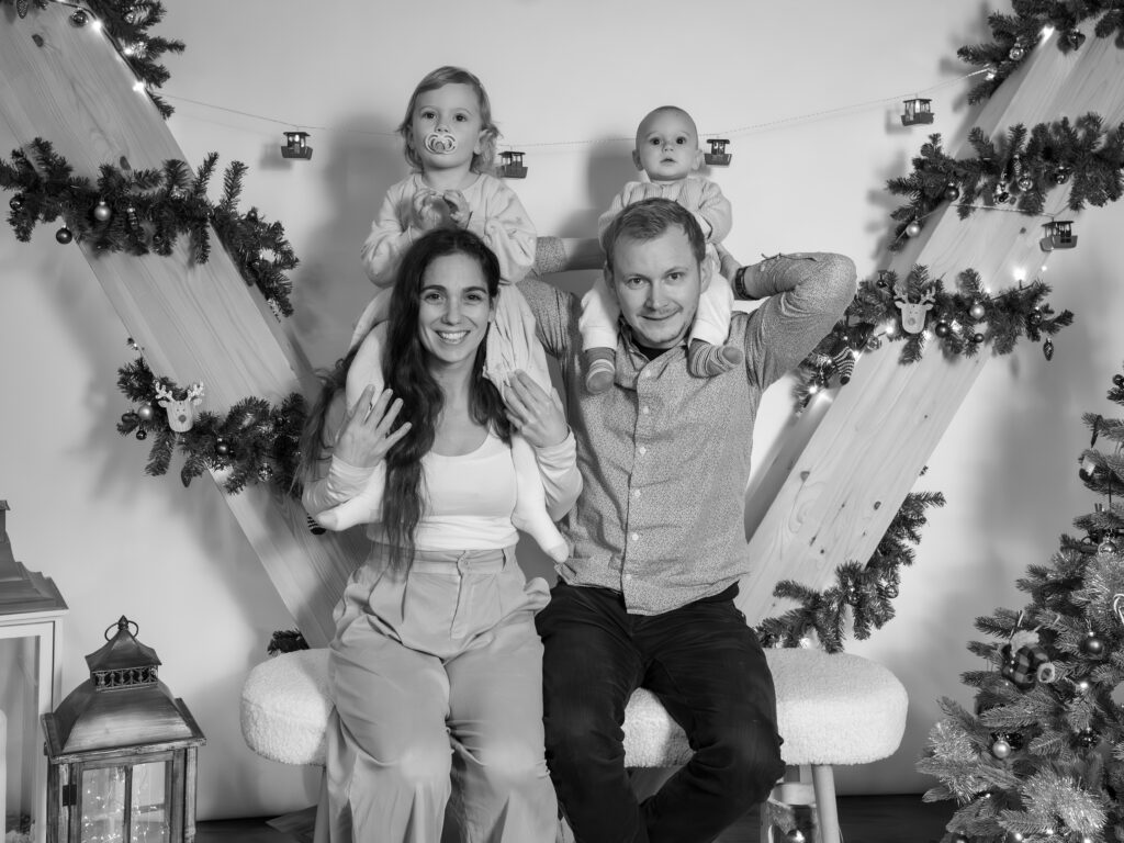 Séance photo famille de Noël en noir et blanc, parents et enfants, photographe famille Suisse