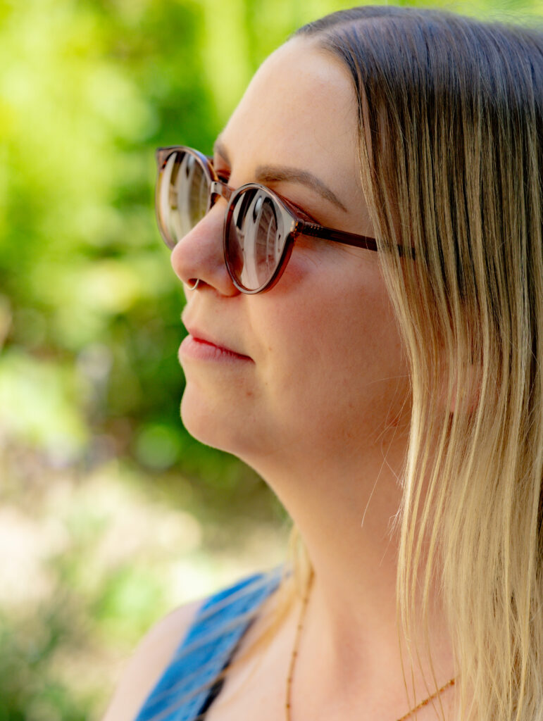 Portrait femme de profil avec lunettes de soleil, lumière naturelle, photographe Suisse romande