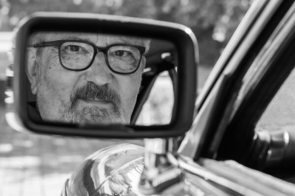 Portrait artistique homme reflété dans rétroviseur, photographie noir et blanc, Suisse